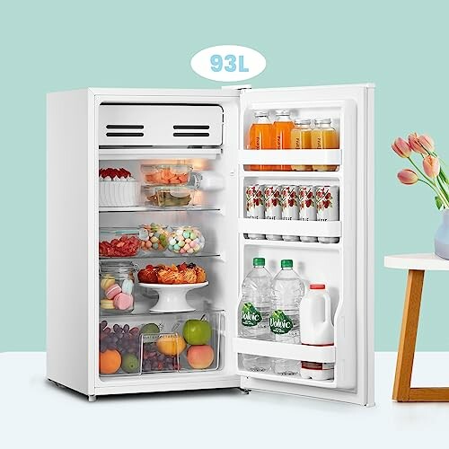 Open compact refrigerator filled with food and drinks.