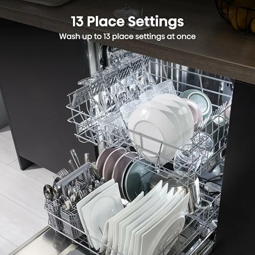 Open dishwasher with 13 place settings including plates, glasses, and cutlery.