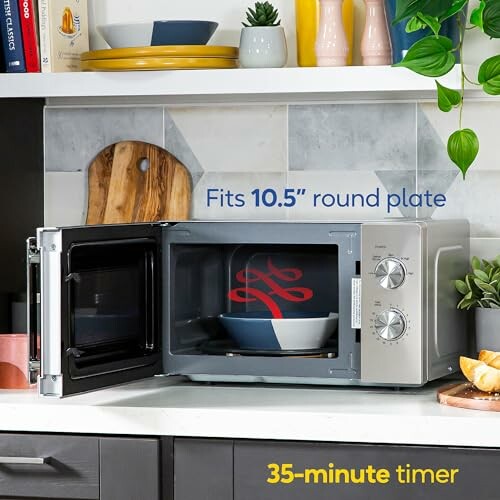 Microwave with open door showing it fits a 10.5 inch round plate, with a 35-minute timer.