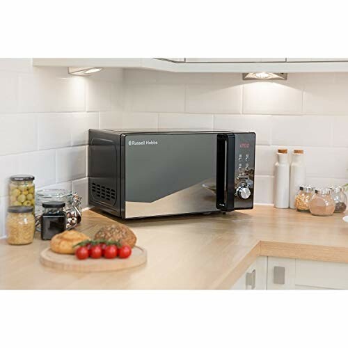 Microwave on a kitchen counter with food items nearby.