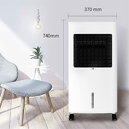 Portable air cooler with dimensions next to a chair and plant.