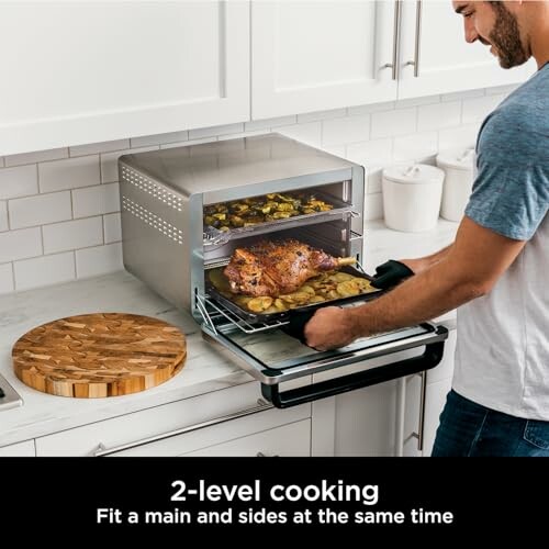 Person using a two-level cooking oven with food inside.