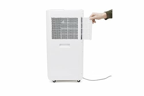 Side view of a white dehumidifier with a hand opening the filter.