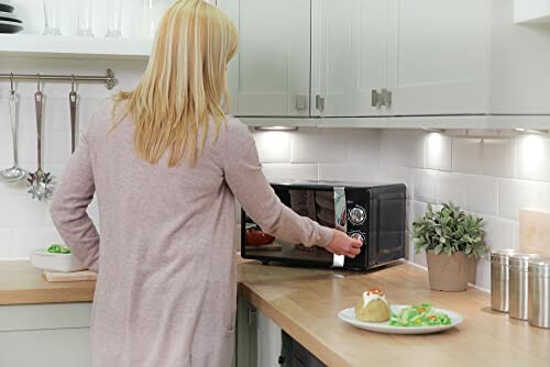 Woman using microwave in a modern kitchen